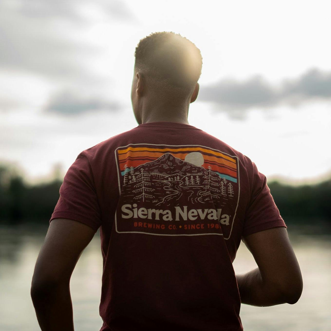 Sierra Nevada Brewing Co. Men's Trail T-Shirt back view worn by a man overlooking a scenic river.