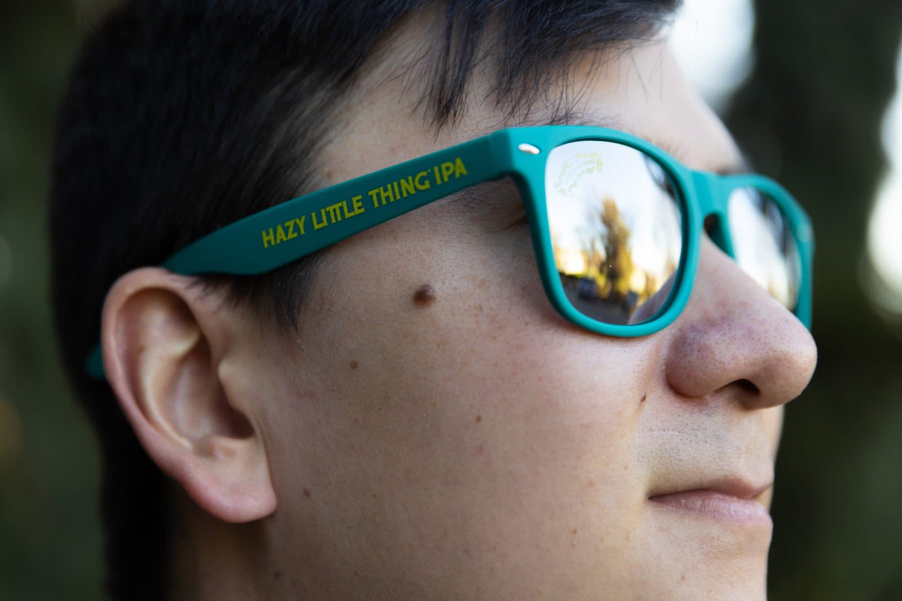 Young man wearing Hazy Little Thing IPA sunglasses