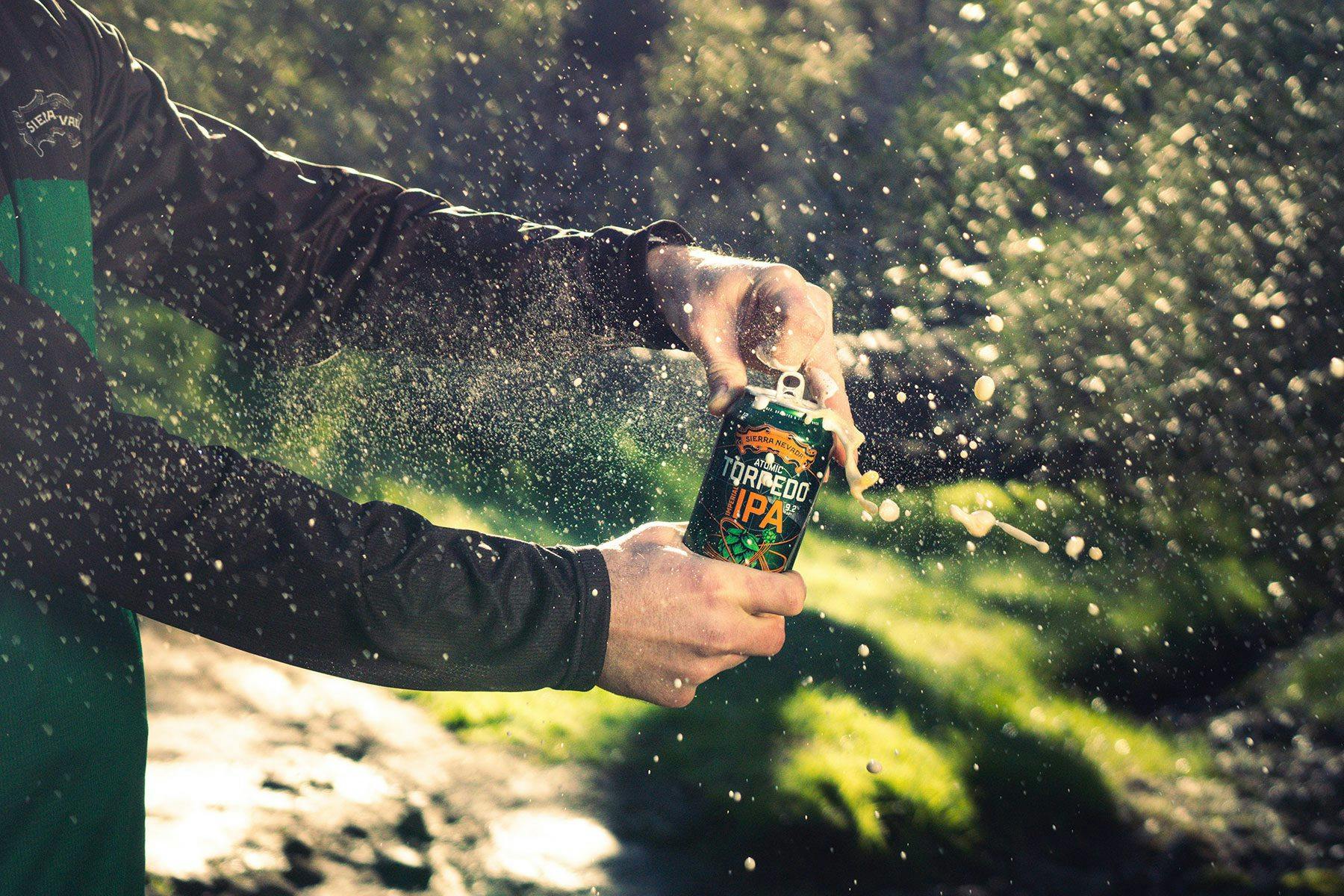 Hands opening a can of Sierra Nevada Atomic Torpedo IPA