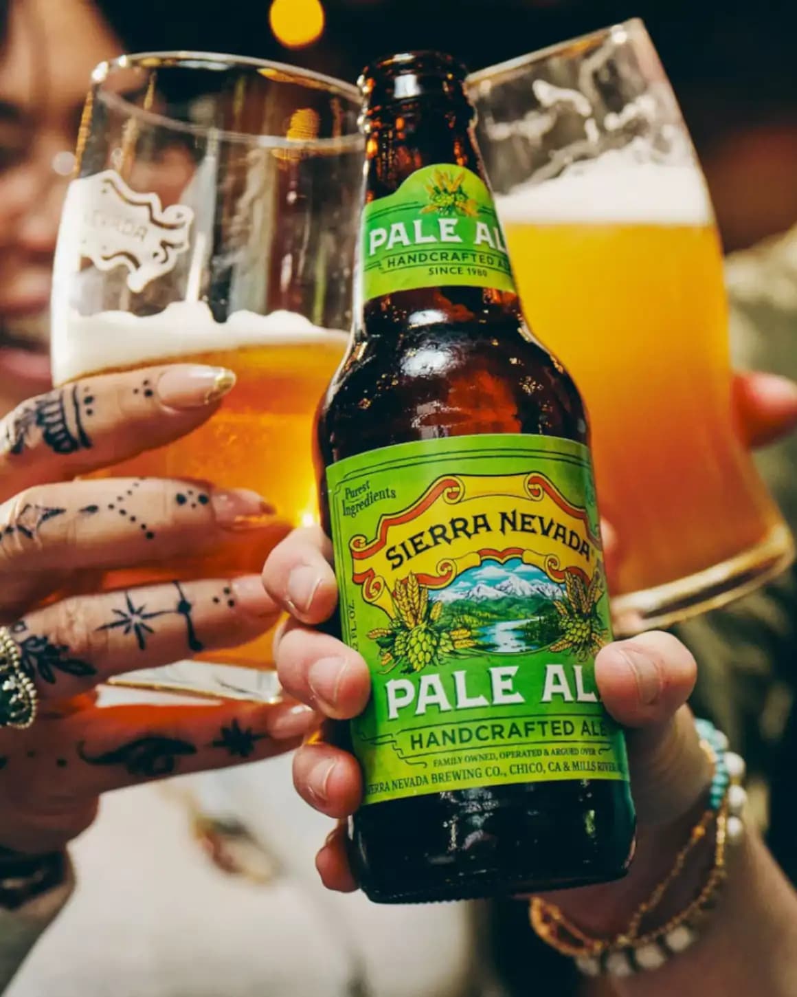 Hands holding bottle and glasses of Sierra Nevada Pale Ale