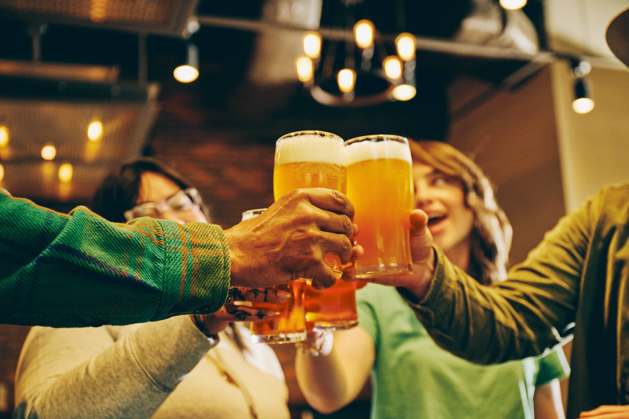 Friends cheersing pints of Sierra Nevada beer in a bar