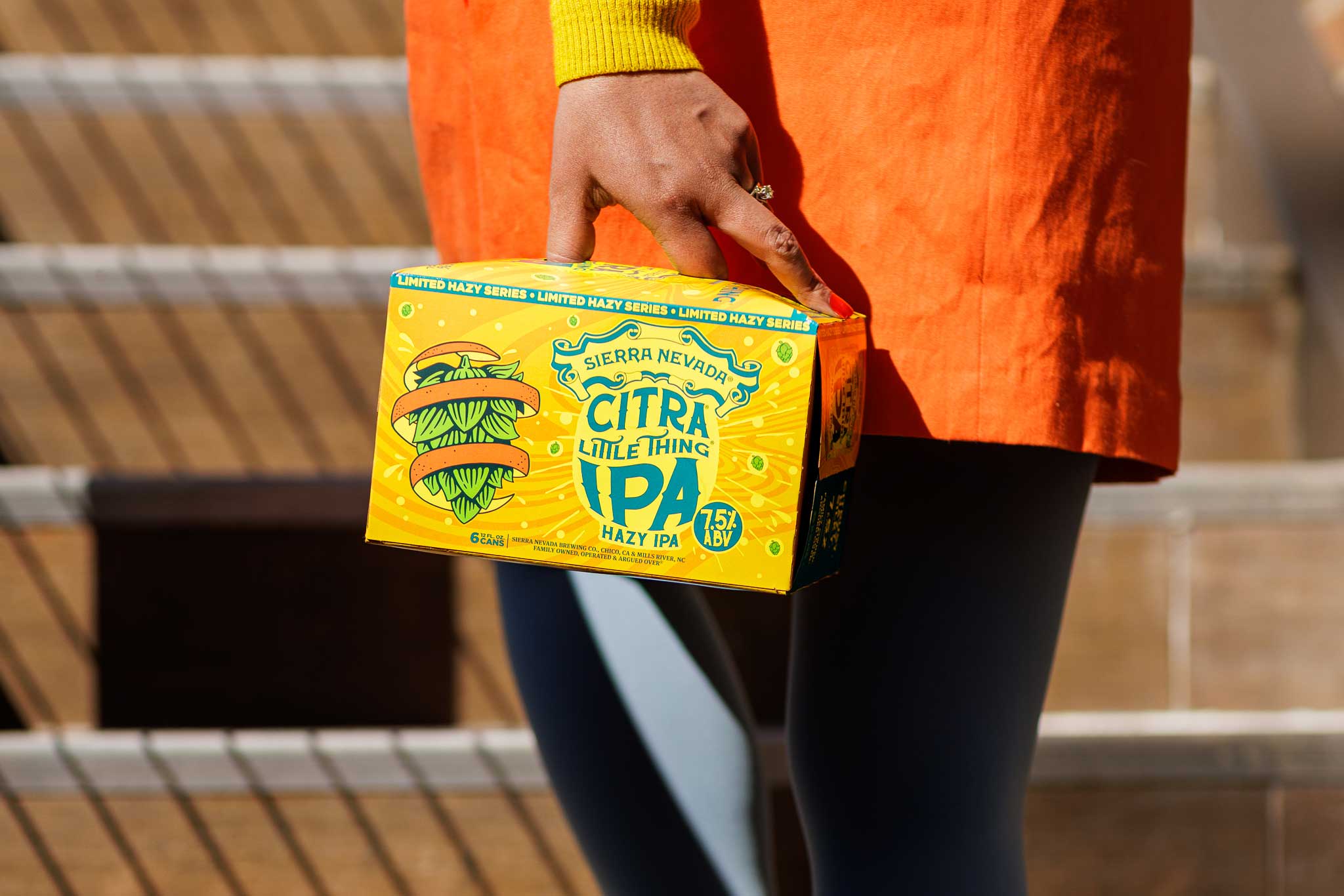 A person on stairs, holding a six-pack of Sierra Nevada Citra Little Thing